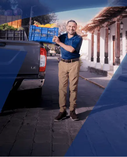 Hombre sonriendo y sosteniendo un canasto con frutas y verduras